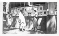 Maud Stumm (L) and Rae Carpenter (R) at the 1931 Sidewalk Art Show. Several Emerson Tuttle etchings hang behind Carpenter.